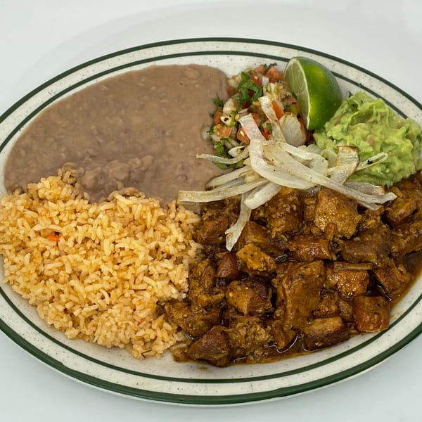 A Mexican dish with rice, refried beans, stewed pork, guacamole, pico de gallo, and grilled onions.