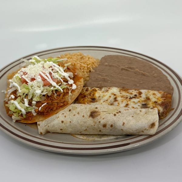 A Mexican combination plate with a tostada, burrito, enchilada, rice, and refried beans.